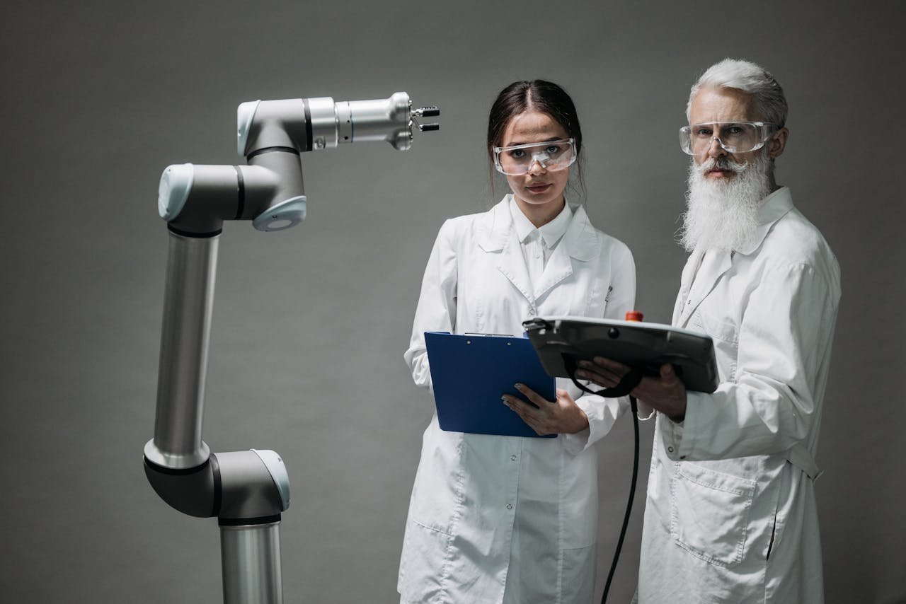 Two scientists in lab coats analyzing a robotic arm in a laboratory setting.